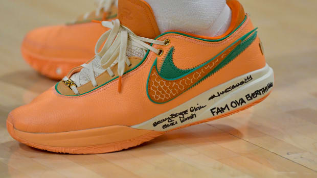View of orange and green Nike LeBron shoe.